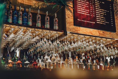 a bunch of wine glasses hanging on a wall