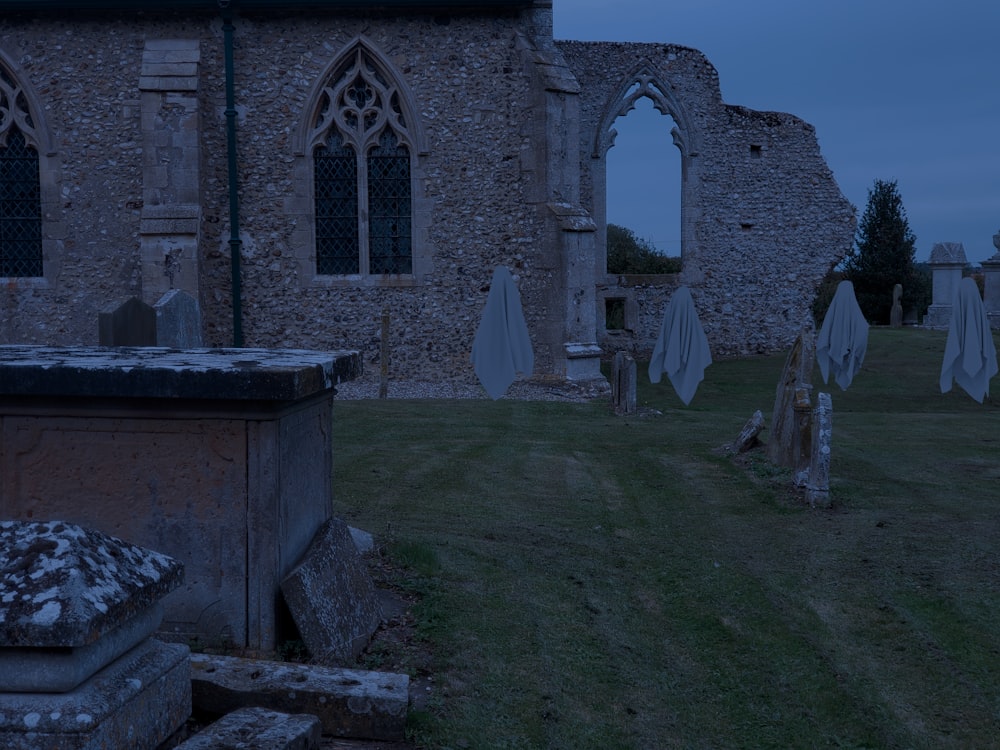 a cemetery with tombstones in front of an old building