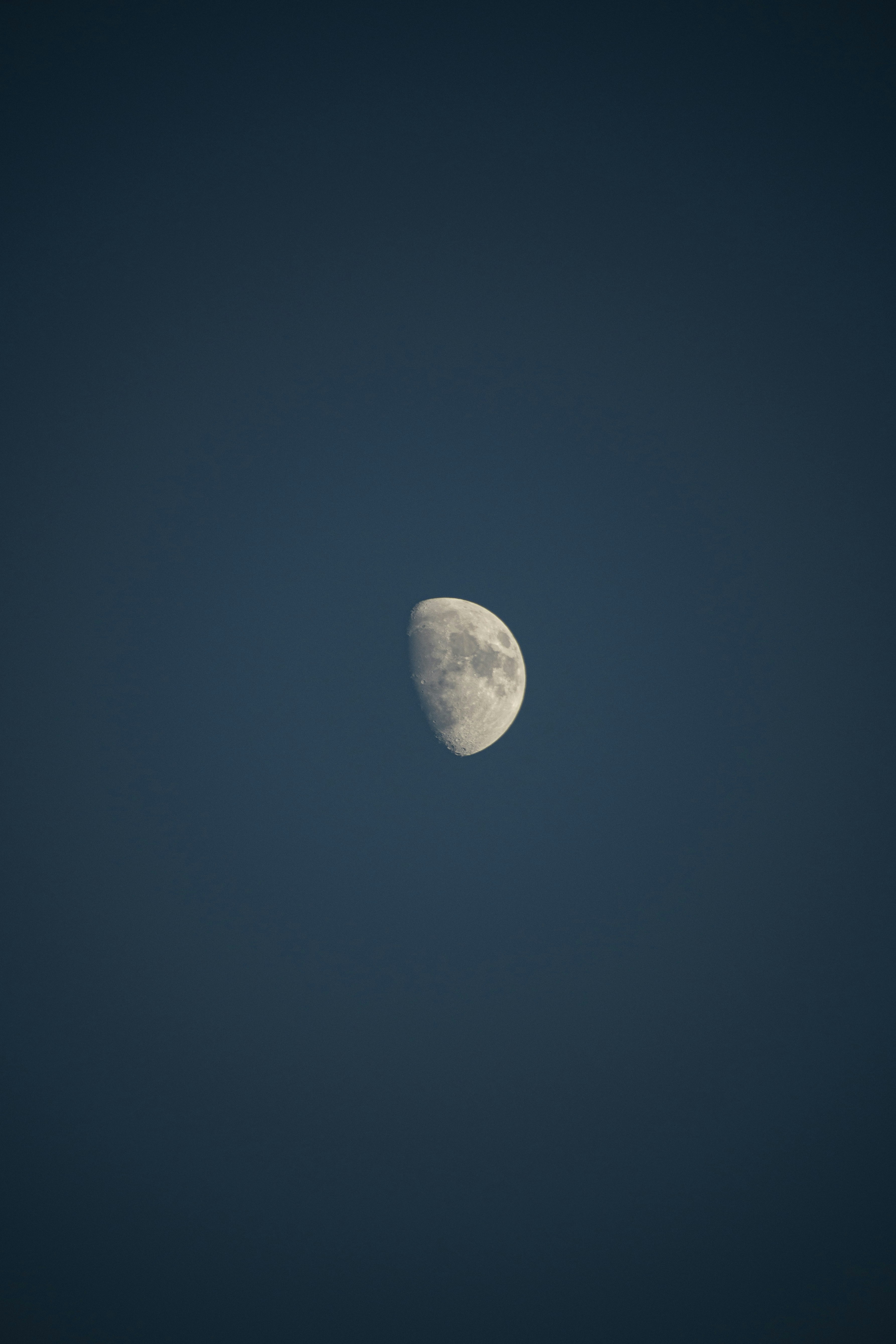 a half moon in a dark blue sky