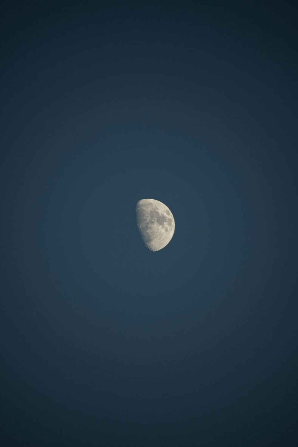 a half moon in a dark blue sky