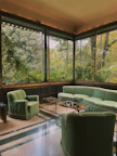 Cozy suite featuring emerald green accents and a plush seating area by the window.
