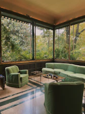 Cozy suite featuring emerald green accents and a plush seating area by the window.