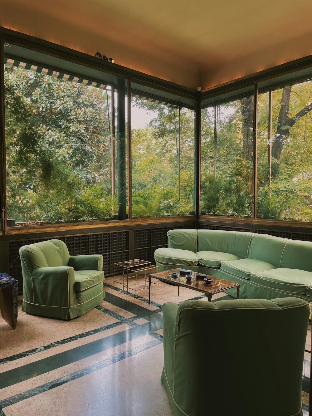 a living room filled with furniture and large windows