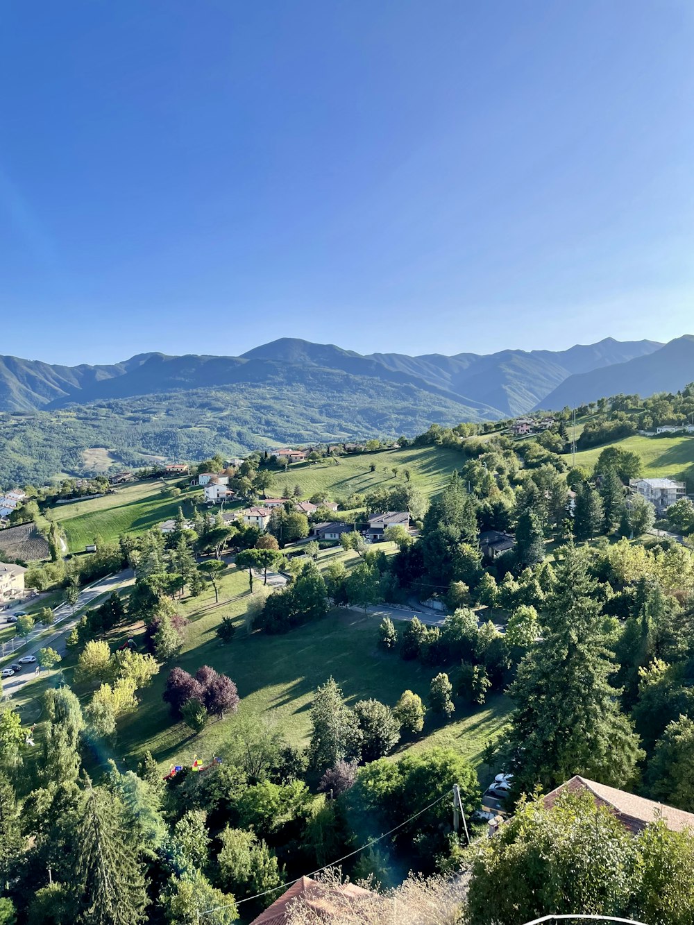 a scenic view of a green valley with mountains in the background