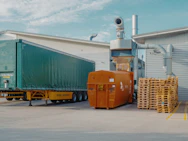 a semi truck is parked in front of a warehouse