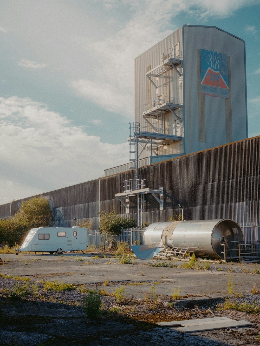 a large industrial building with a train next to it