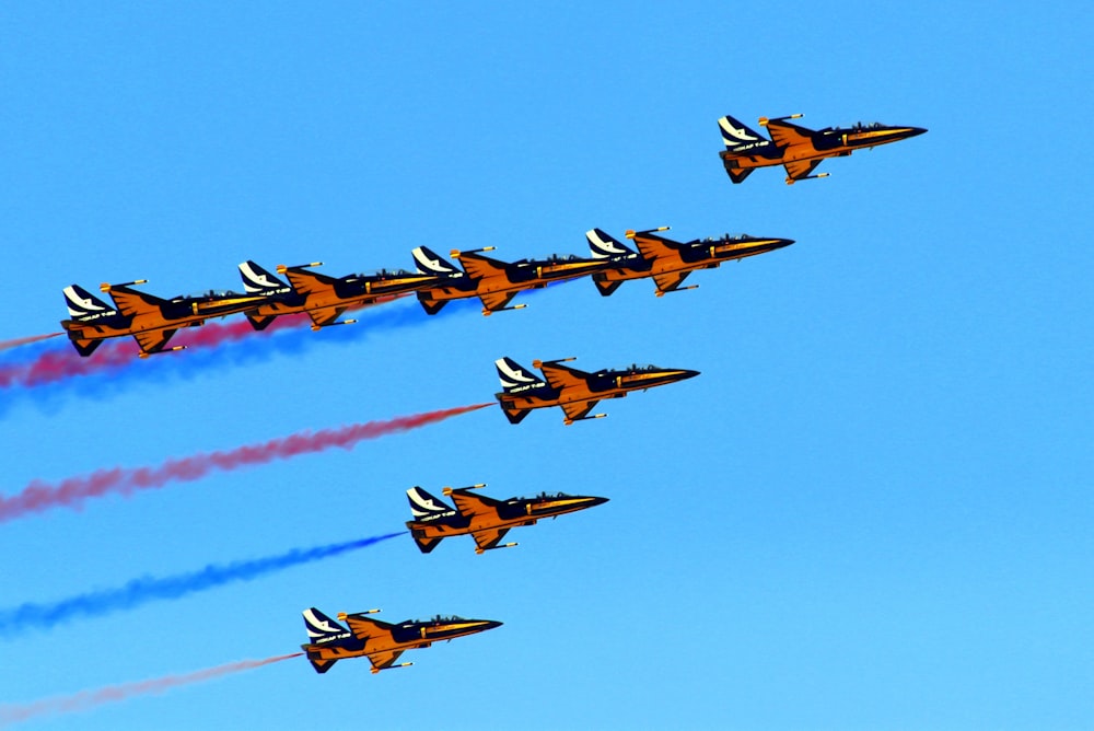 a group of fighter jets flying through a blue sky