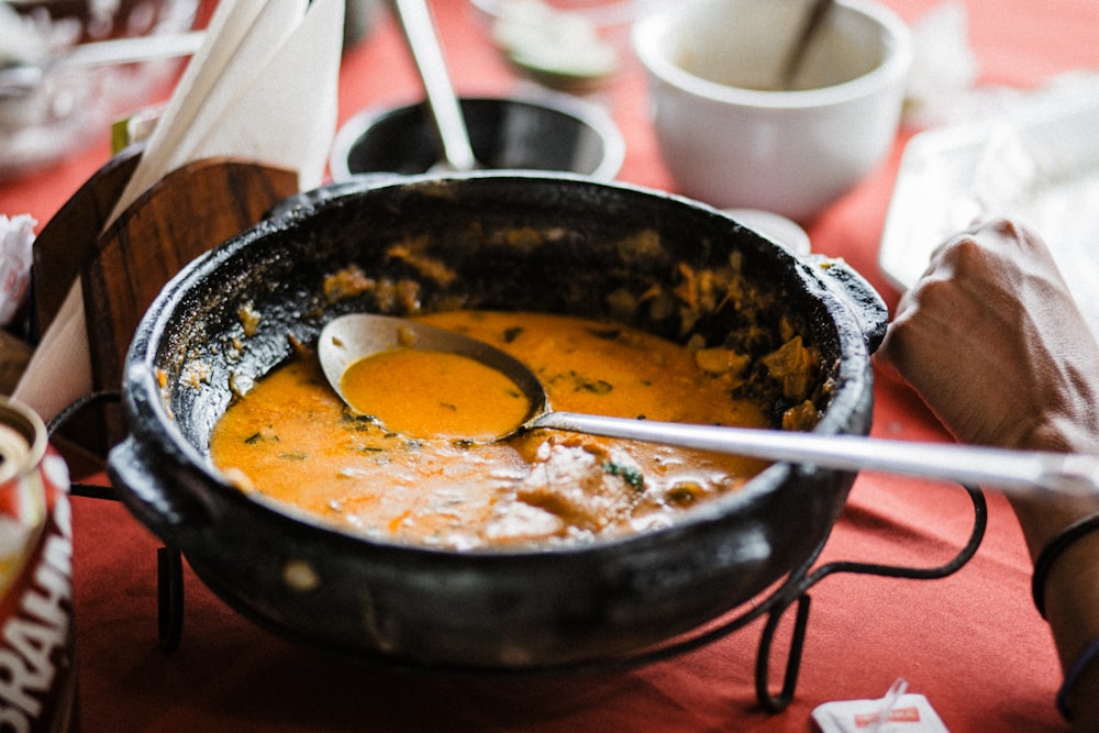 eine Schüssel Suppe mit einem Löffel darin