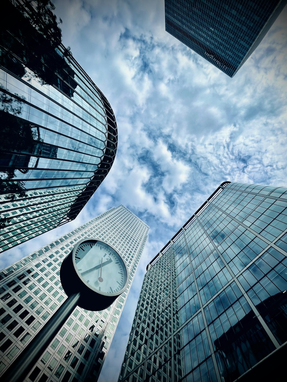 a clock is in the middle of a group of tall buildings