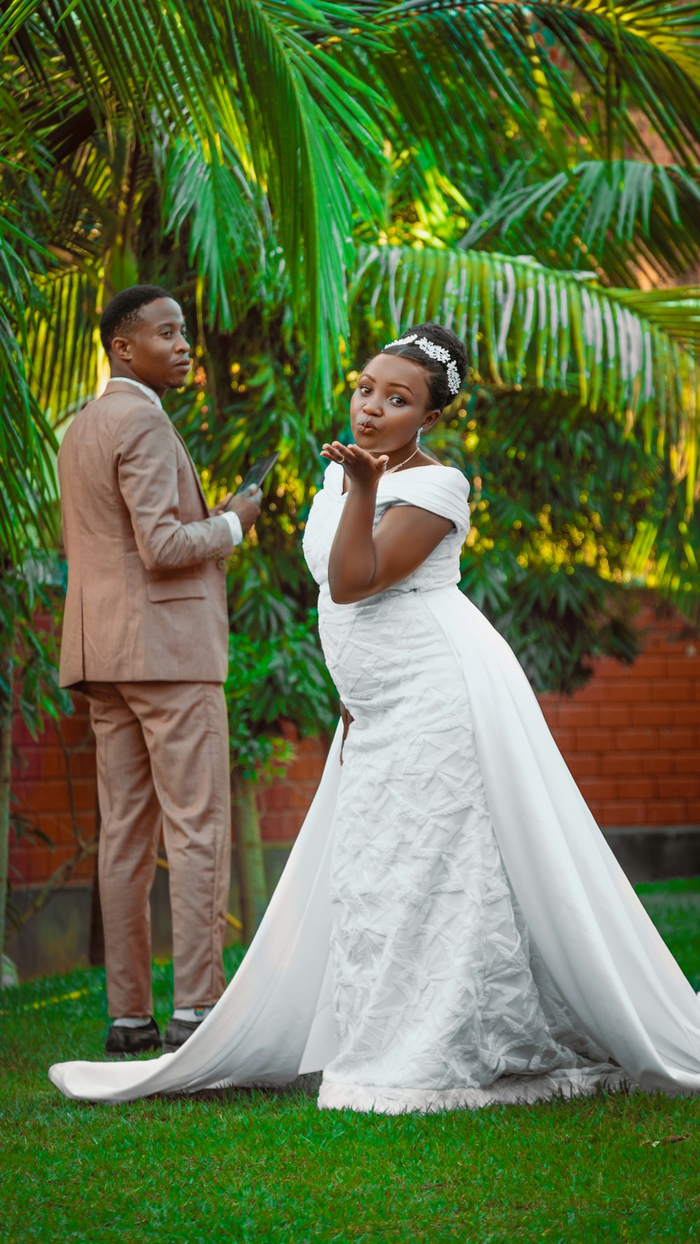 a woman in a wedding dress standing next to a man in a suit