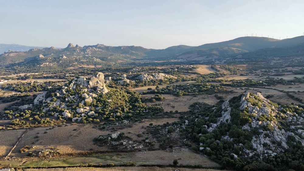 an aerial view of a valley with mountains in the background