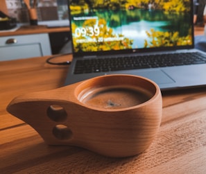 A stylish travel thermos coffee cup on a wooden table.