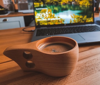 A stylish travel thermos coffee cup on a wooden table.