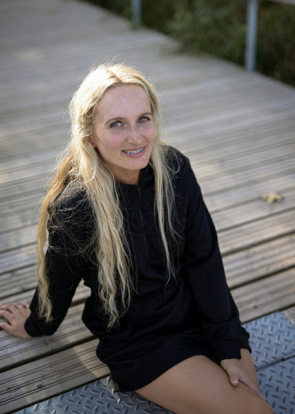 a woman is sitting on a wooden platform