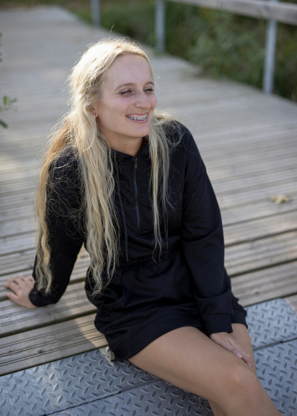 a blonde woman sitting on a wooden bench