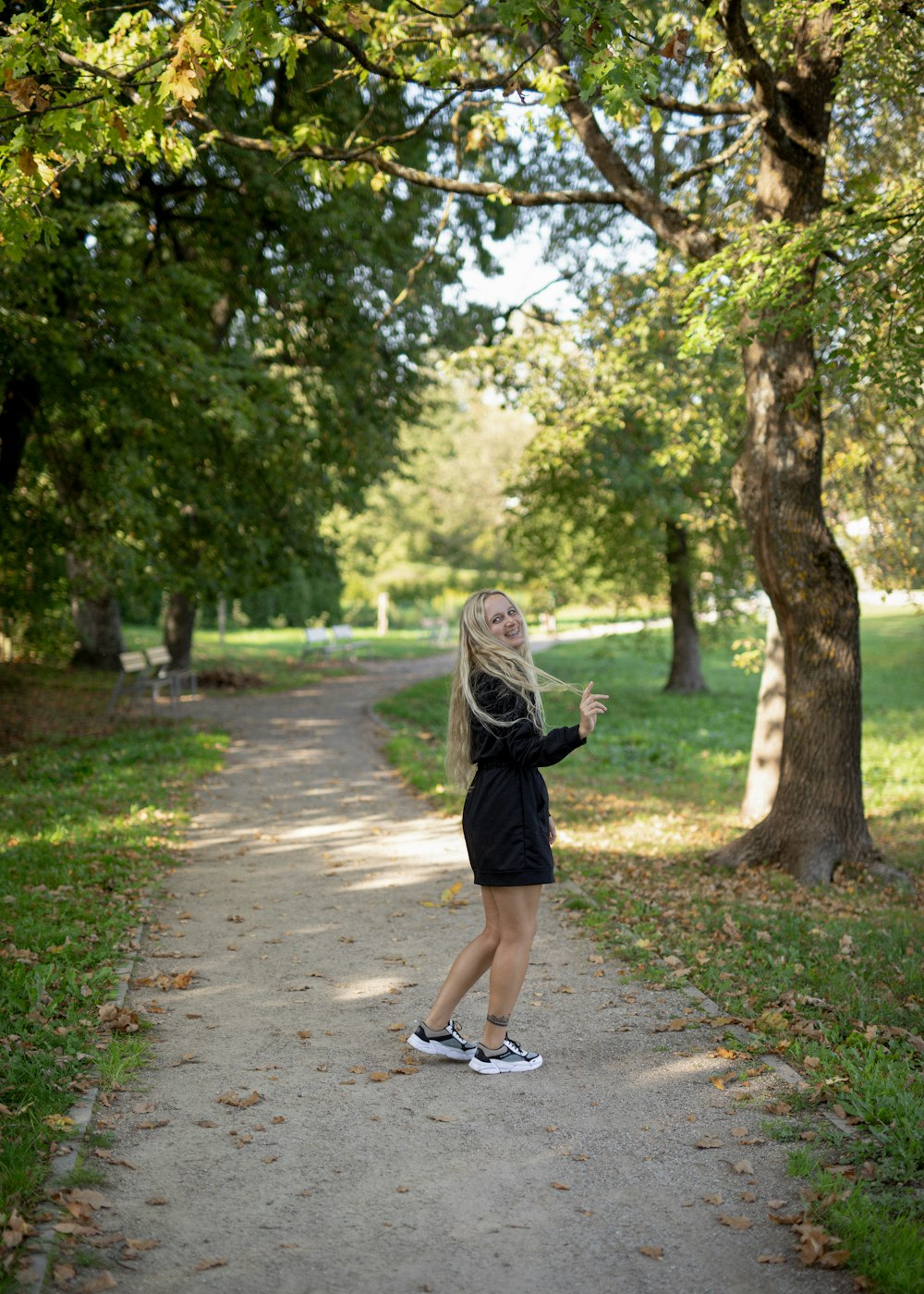 a woman standing on a path in a park