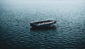 a small boat floating on top of a large body of water