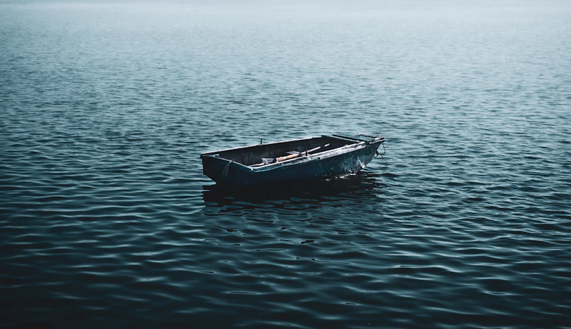 a small boat floating on top of a large body of water