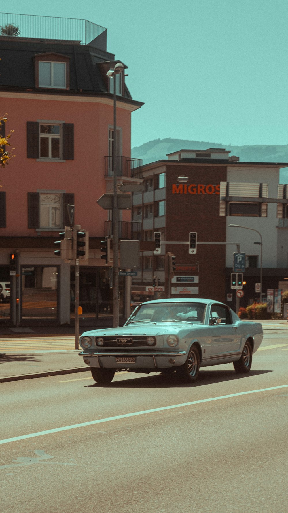 a car driving down a street next to tall buildings