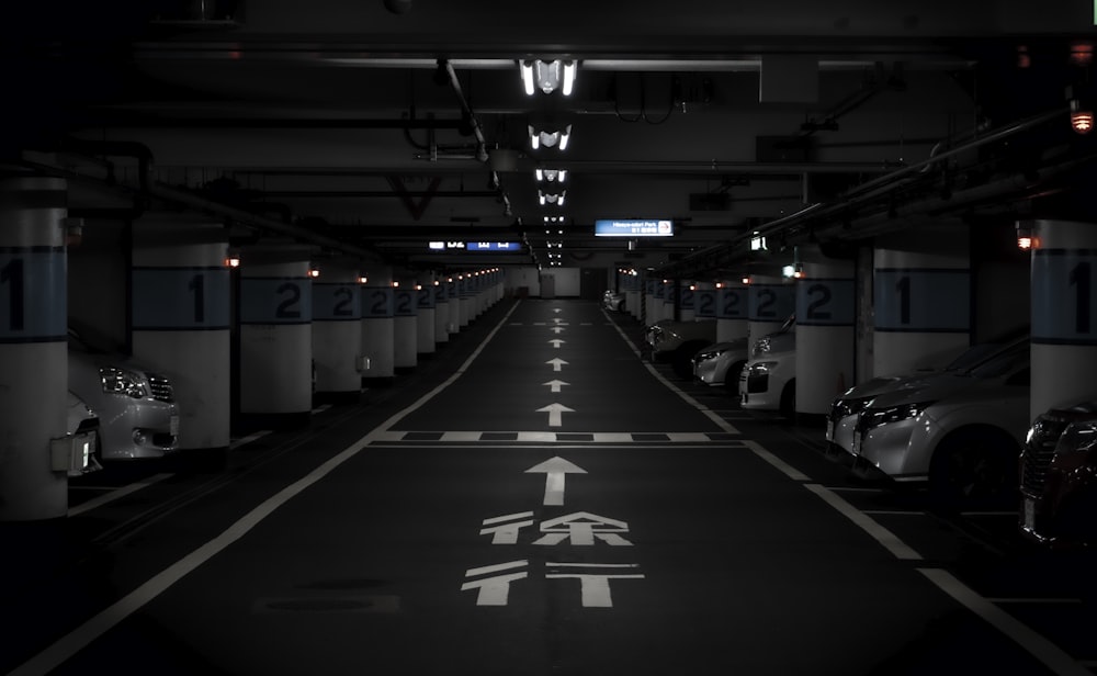 an empty parking garage filled with lots of parked cars