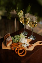 Various cheese boards featuring intricate designs, set against a background of fresh grapes and wine.