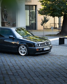 A sleek VW car parked on a scenic Dutch street, showcasing the perfect fit of new tires.