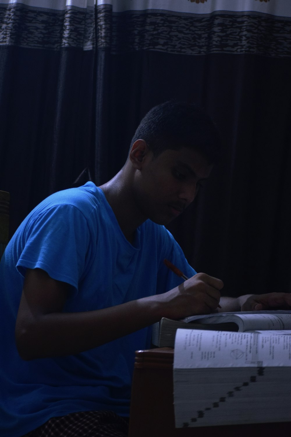 a man sitting at a desk writing on a piece of paper