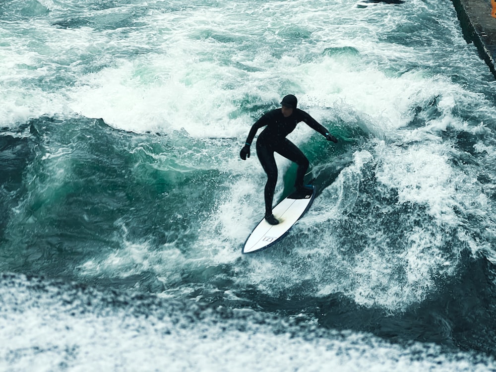 a man riding a wave on top of a surfboard