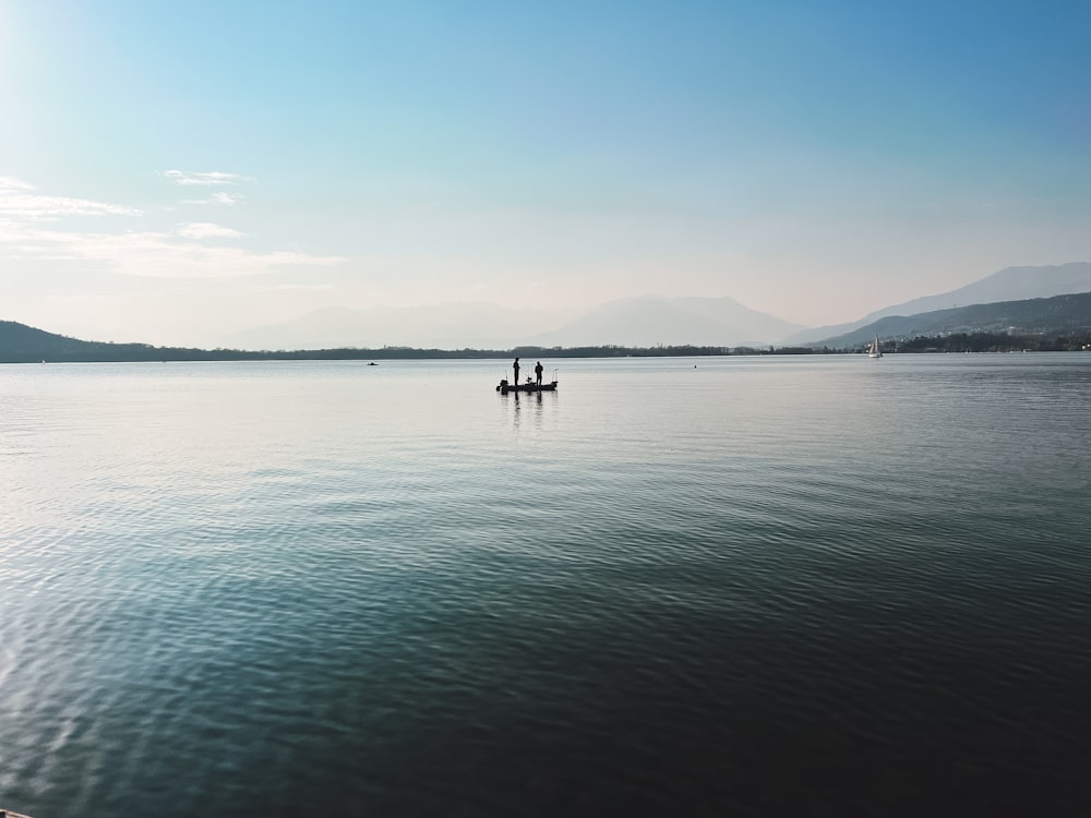 two people in a boat on a large body of water