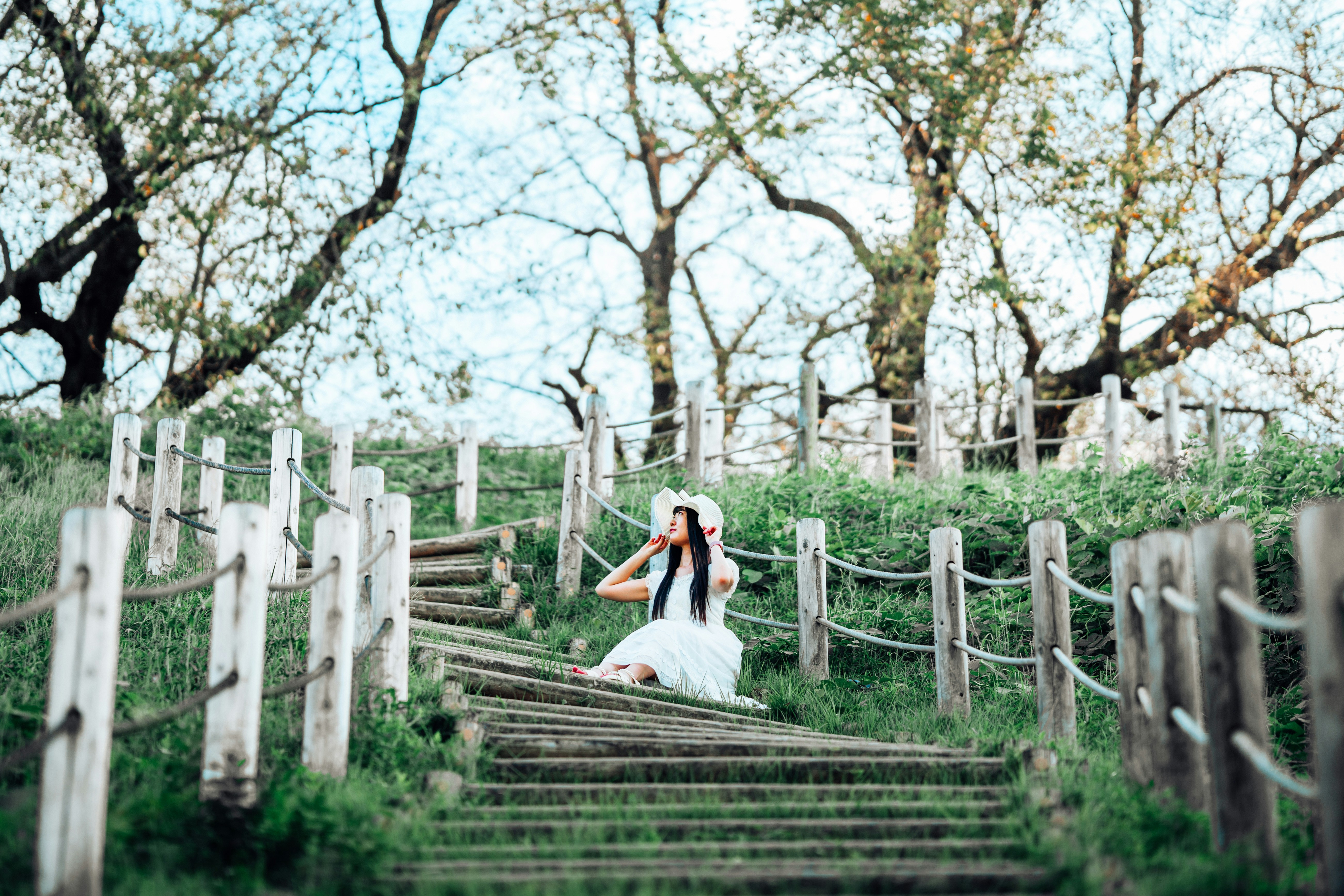 a woman in a white dress is walking down a set of stairs
