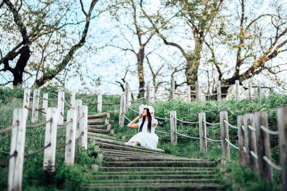 a woman in a white dress is walking down a set of stairs