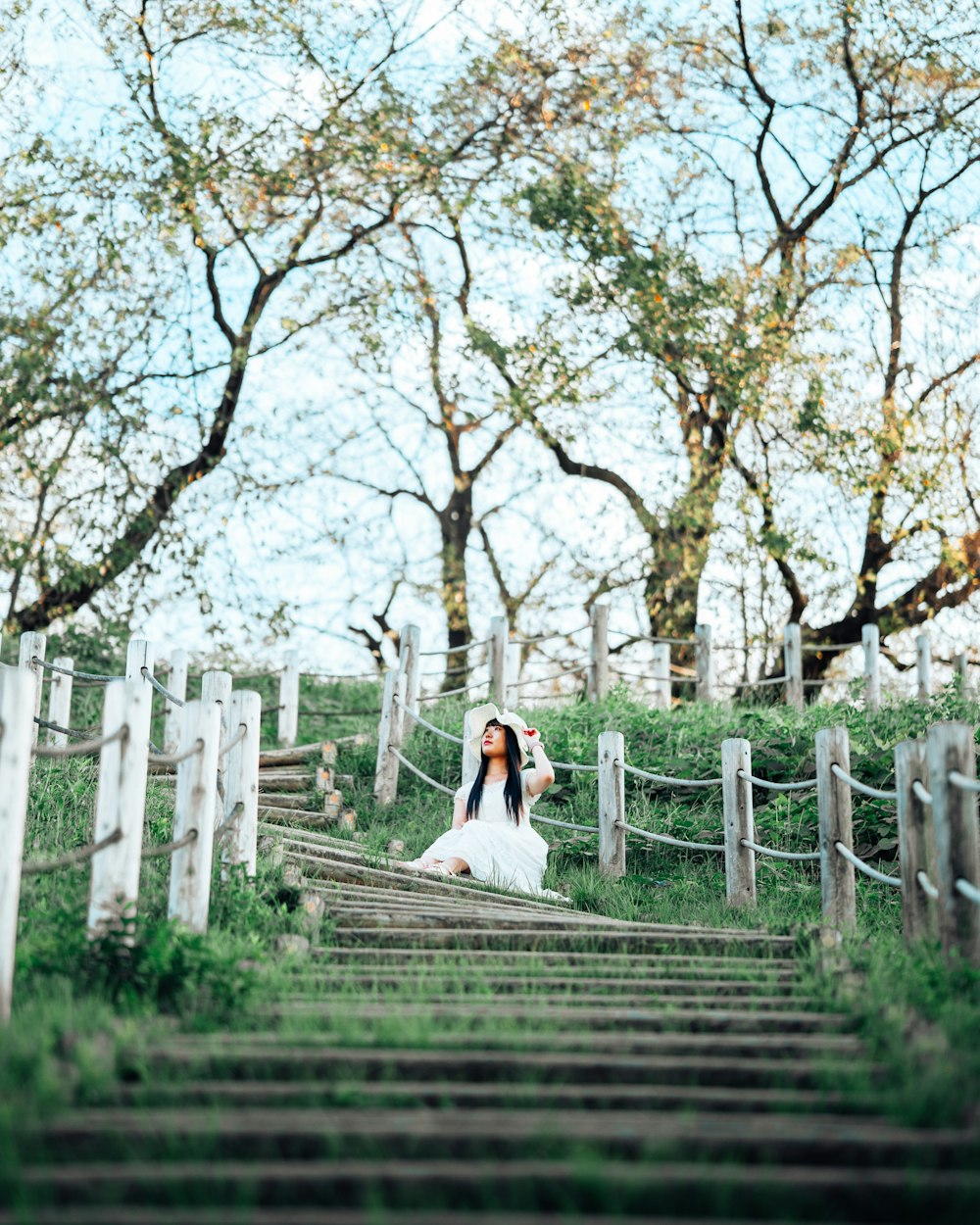 a woman in a white dress walking up a set of stairs