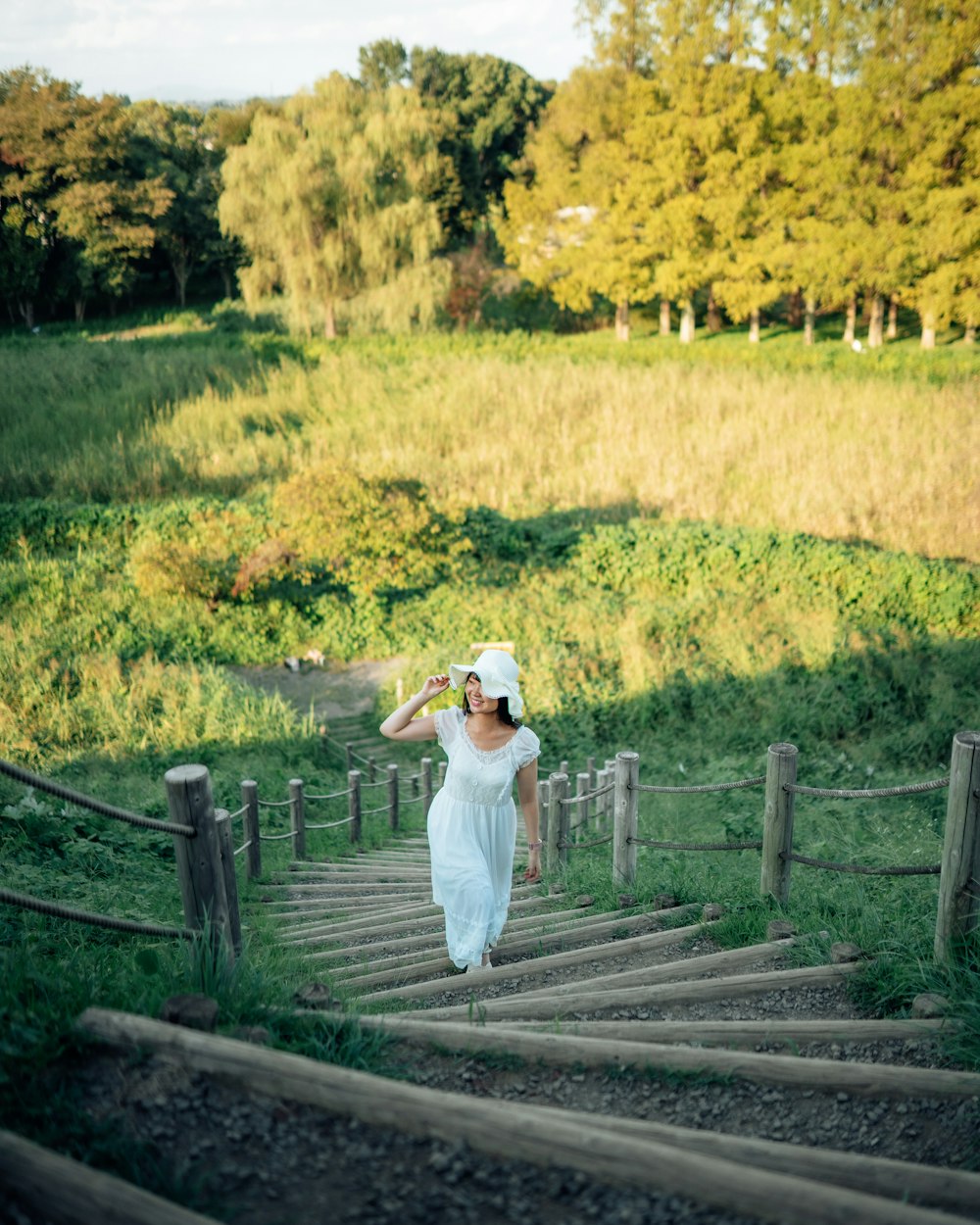 a woman in a white dress is walking down a set of stairs