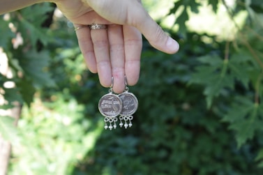 a person holding a coin with a chain around it