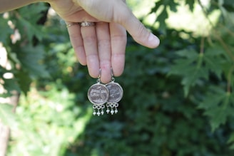 a person holding a coin with a chain around it