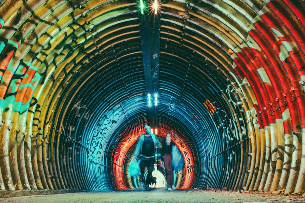 a group of people riding horses through a tunnel