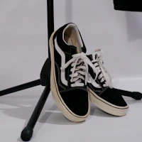 Stylish sneakers with brown and black tones resting beside a vintage microphone.