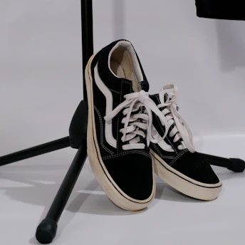 Stylish sneakers with brown and black tones resting beside a vintage microphone.