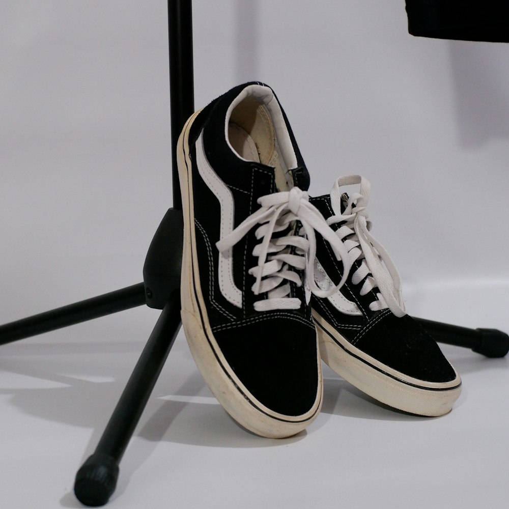 a pair of black and white shoes sitting on top of a chair