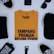 A neatly arranged flat lay featuring a mustard yellow t-shirt with bold black lettering at the center. Surrounding the shirt are various items: a pair of black sneakers with white laces, a black smartphone, round black sunglasses, a black cap, a black pouch with 'TALK LESS DO' printed in white, and a black belt.