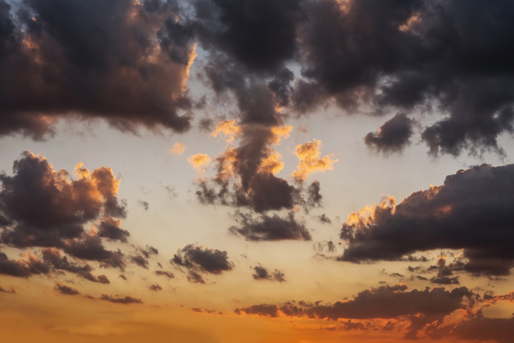 a plane flying in the sky at sunset