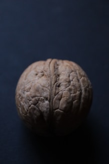 a close up of a walnut on a black surface