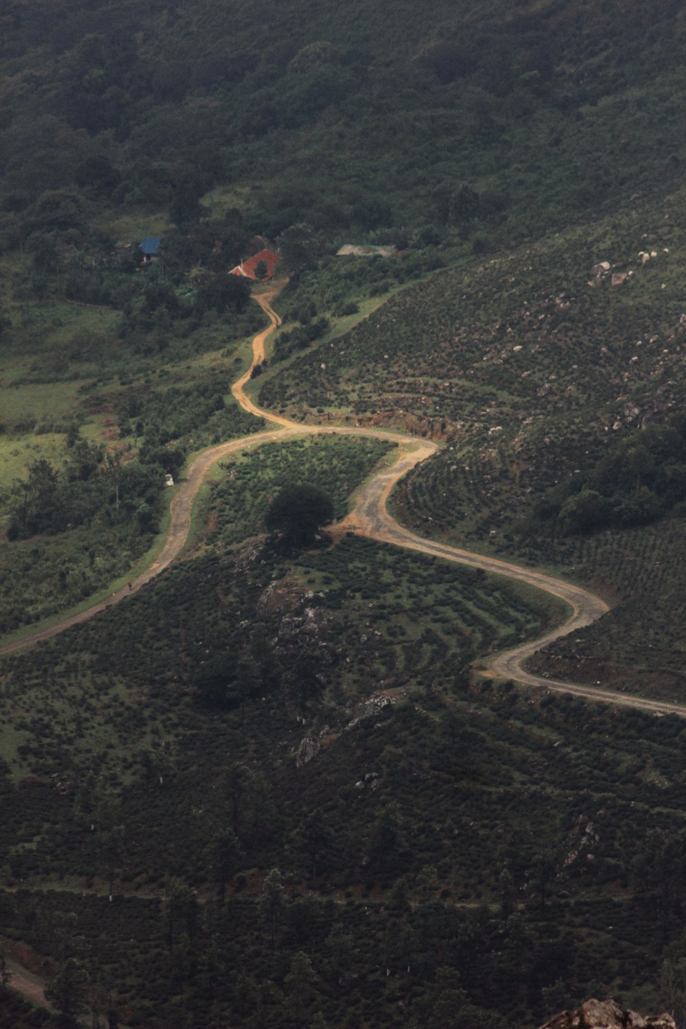 an aerial view of a winding road in the mountains