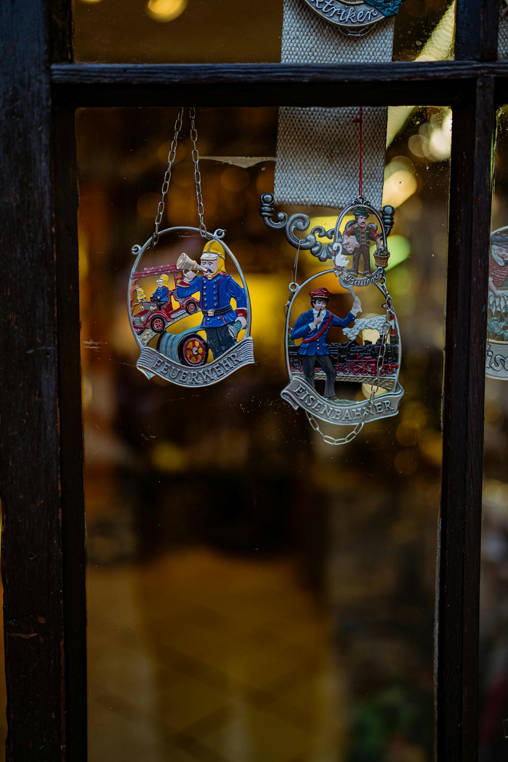 a window with a couple of ornaments hanging from it's side