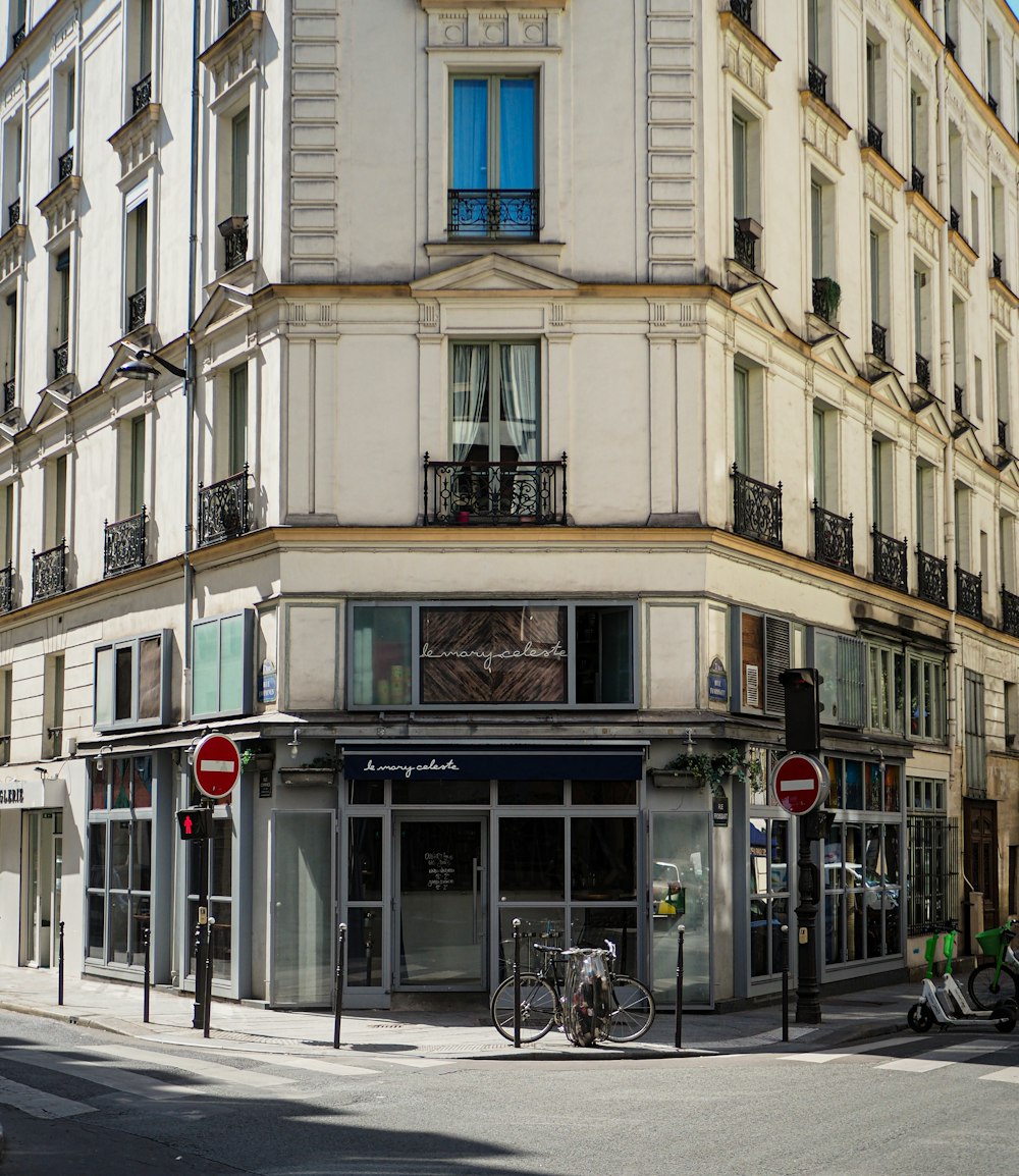 a street corner with a building and a bicycle parked in front of it