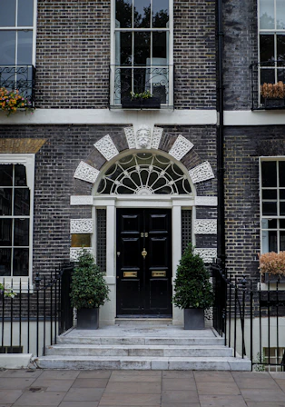 a building with a black door and a black fence