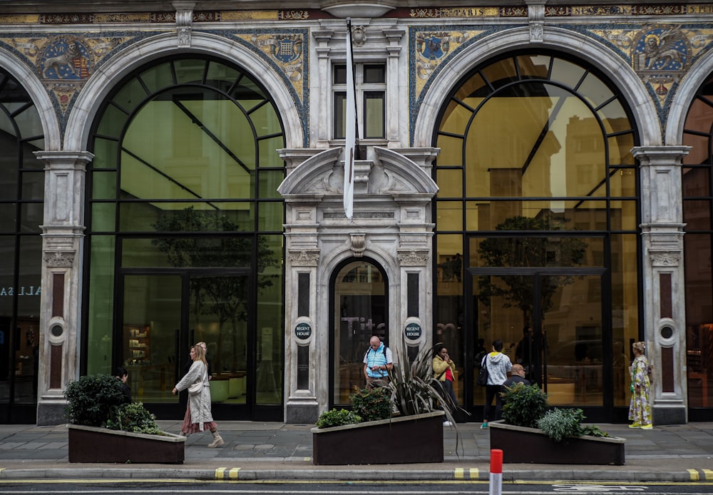 a group of people walking past a tall building