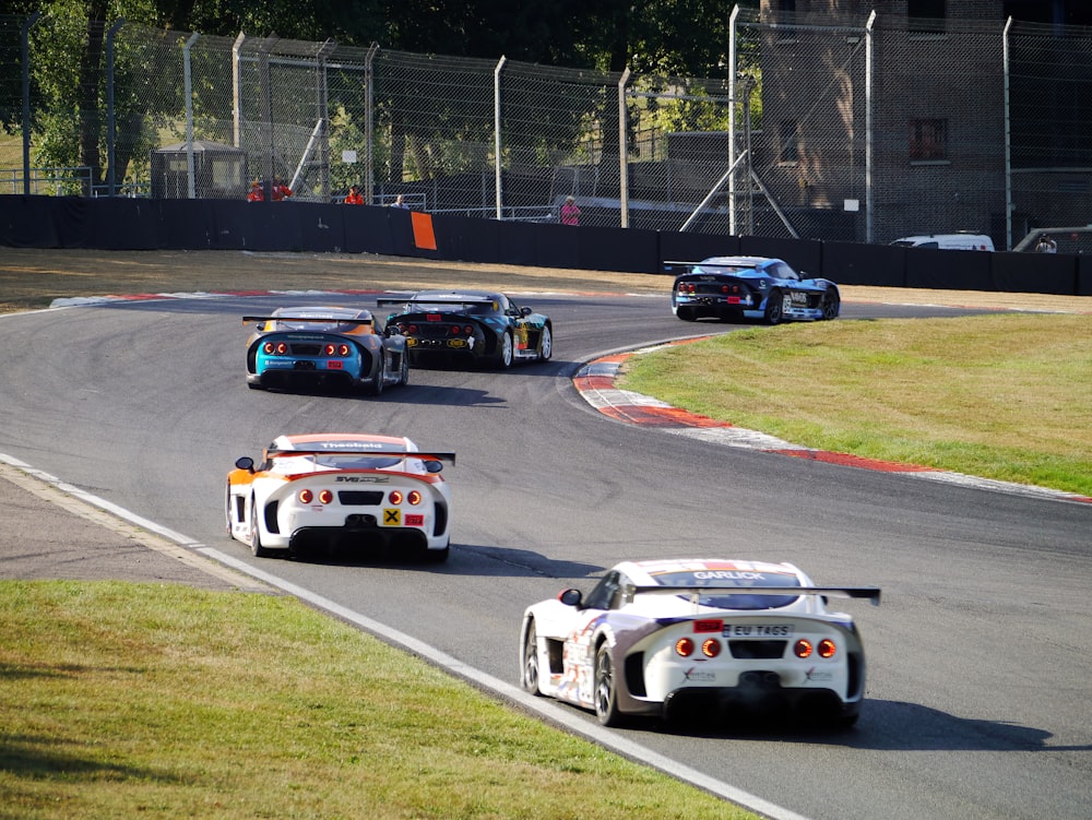 um grupo de carros dirigindo por uma pista de corrida