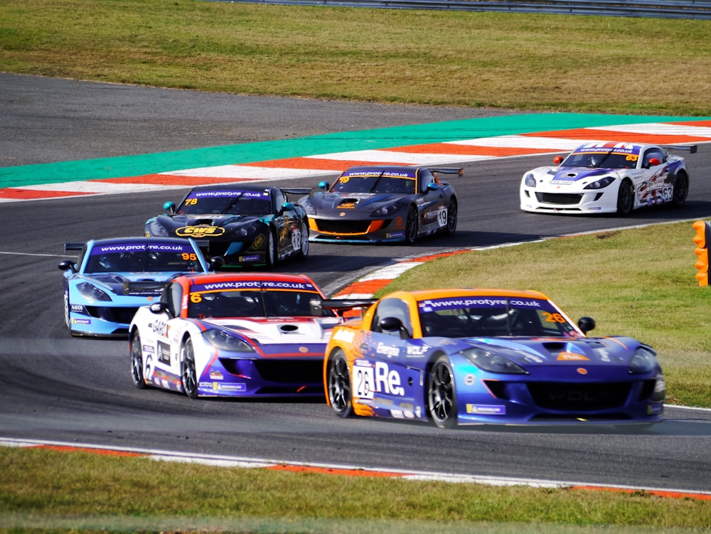 um grupo de carros correndo em uma pista de corrida