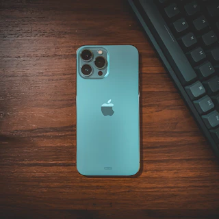 A sleek turquoise and black tech gadget with orange accents on a modern desk.